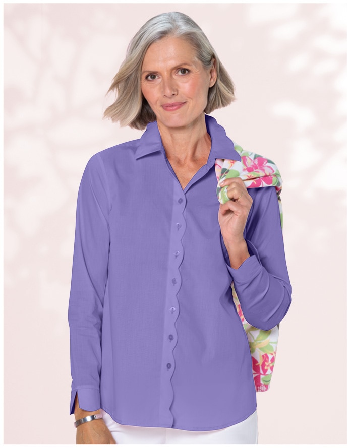 woman facing the camera wearing a purple shirt with a floral print draped over her shoulder